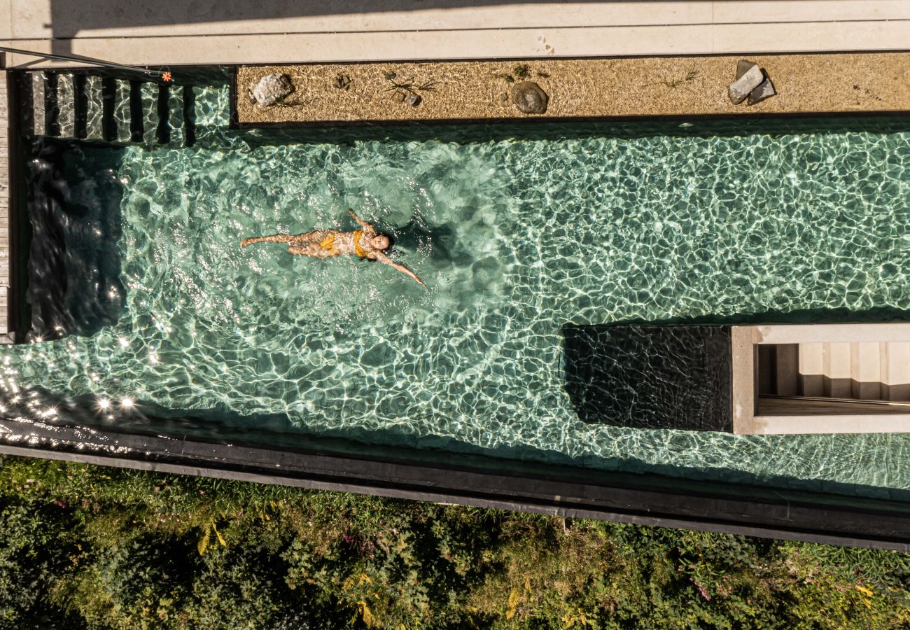 Shot from above of girl swimming in beautiful pool in Design Apartments VIU by we rent