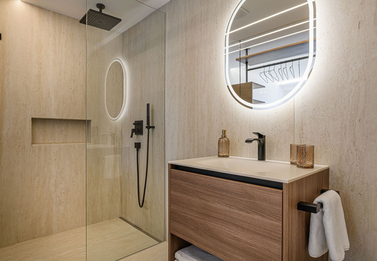 Schönes Badezimmer mit Waschbecken und Dusche in Design Apartments VIU by we rent